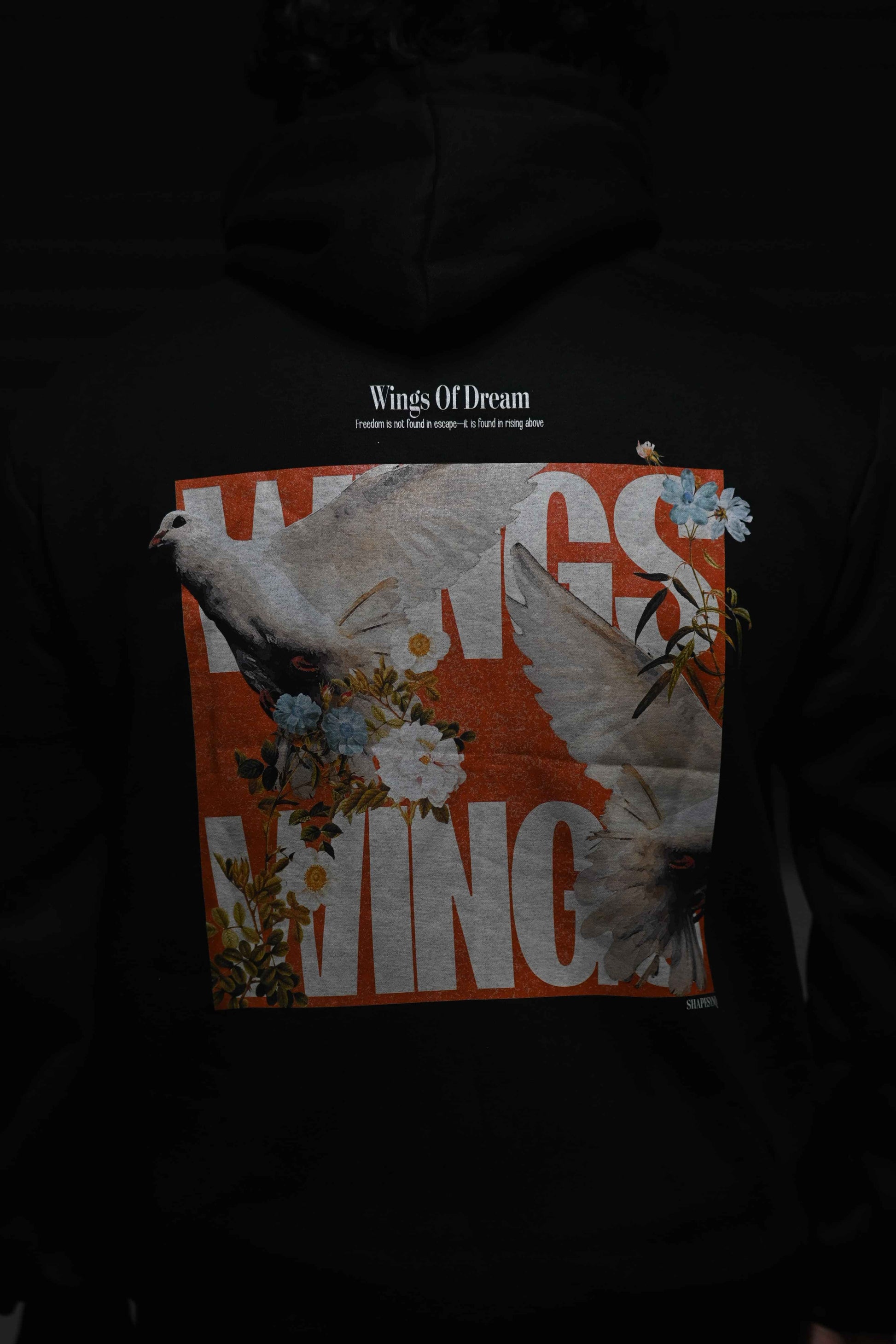 Black hoodie featuring a colorful 'Wings' graphic with birds and flowers for a stylish look
